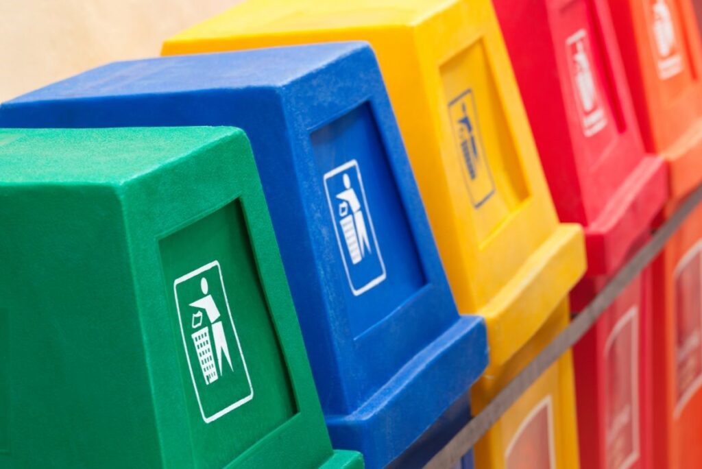 Close up of four waste recycling bins of different colours in a row